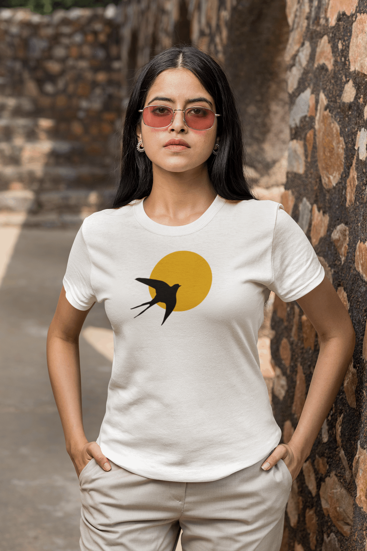 White unisex organic t-shirt with a minimalist Andorinha swallow design, worn outdoors. A breathable and stylish choice inspired by Portuguese heritage.