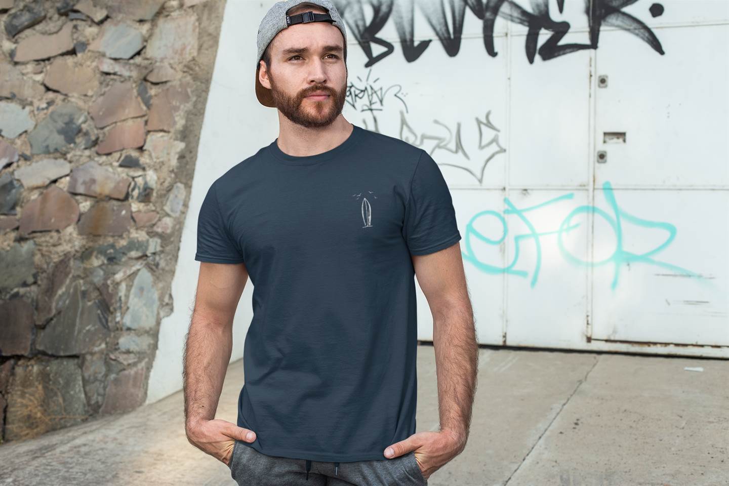 Ericeira Surfboard Organic Menās T-Shirt in navy blue, featuring a minimalist surfboard design on the chest. Made from GOTS-certified organic cotton.