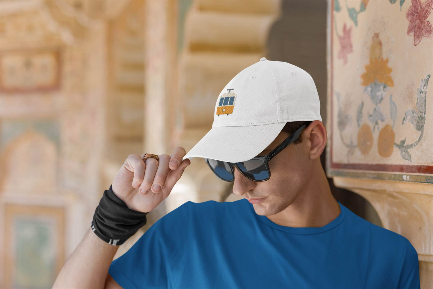 White Lisbon Tram Cap with minimalist embroidery, worn by a man in sunglasses. A stylish unisex cap celebrating Lisbon's historic tram culture.