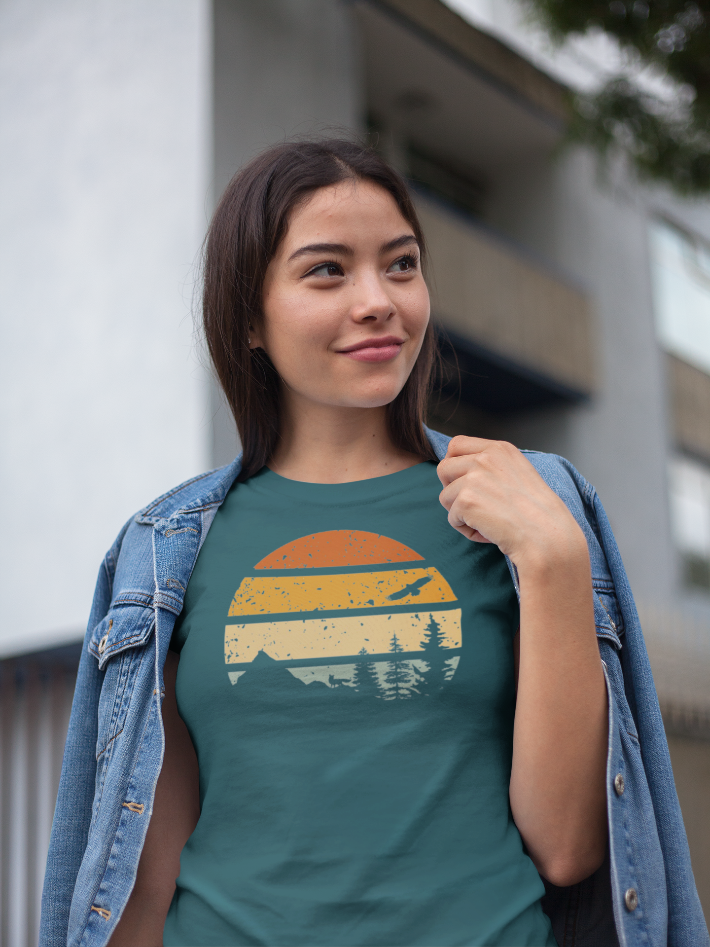 Young woman in a teal Madeira Mountains Retro Organic Vintage T-Shirt, styled with a denim jacket. A trendy hiking tee for outdoor lovers.