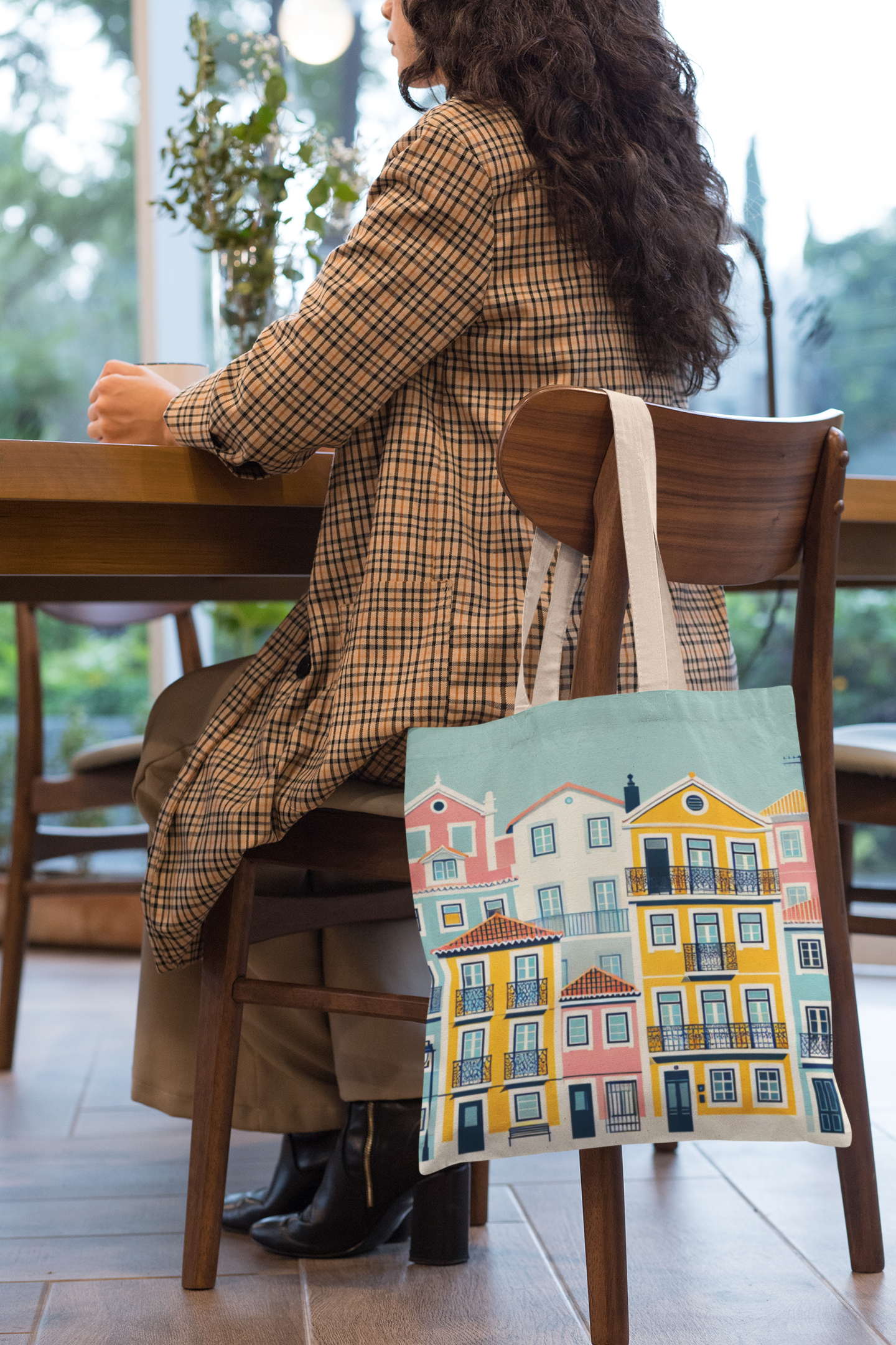 Lisbon Tote Bag from the Alfama Collection hanging on a chair in a cozy cafƩ. A stylish and practical accessory for everyday use.