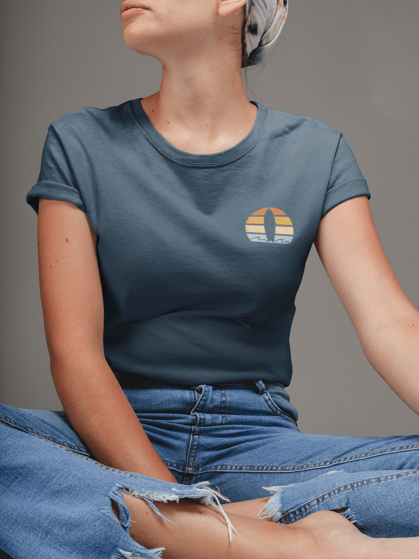 Woman wearing a navy blue Nazare Surf Minimal Organic T-shirt with a vintage surf logo. Soft, sustainable cotton for a stylish and eco-friendly look.