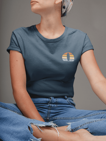 Woman wearing a navy blue Nazare Surf Minimal Organic T-shirt with a vintage surf logo. Soft, sustainable cotton for a stylish and eco-friendly look.