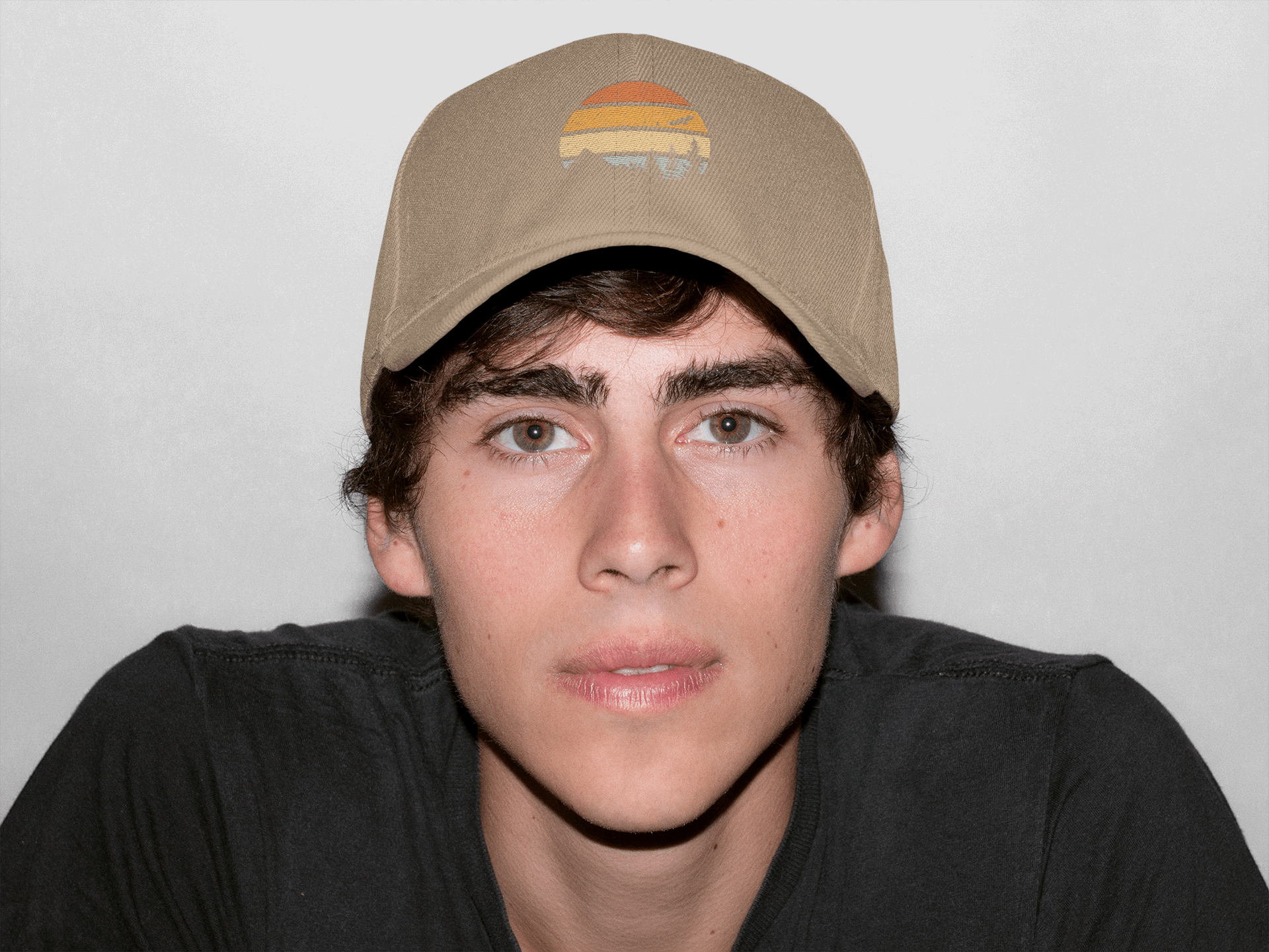 Beige Madeira Vintage Cap featuring a mountain logo, worn by a young man. A versatile and timeless adventure-style cap.