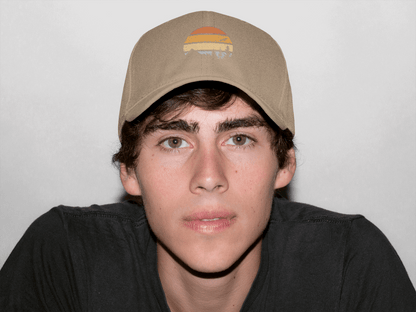 Beige Madeira Vintage Cap featuring a mountain logo, worn by a young man. A versatile and timeless adventure-style cap.