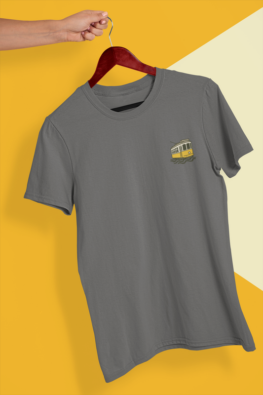 Gray t-shirt with a small yellow graphic on a hanger against a yellow and beige background