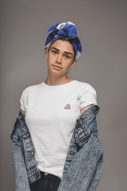 Woman in a white Minimal Alfama Houses Unisex T-Shirt with a denim jacket, showcasing the small Lisbon-inspired house design on organic cotton.