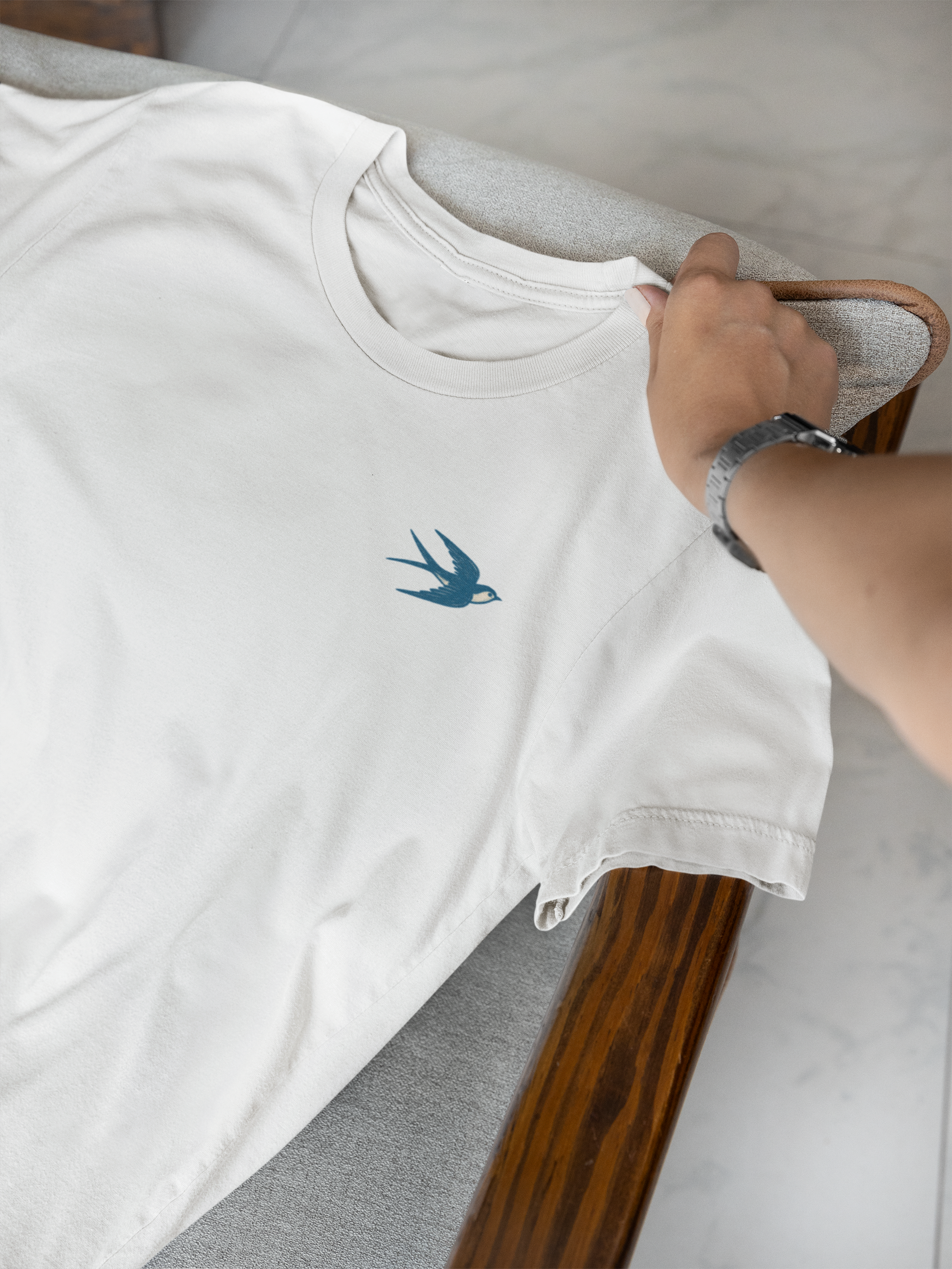 White sustainable shirt featuring minimal swallow line art.