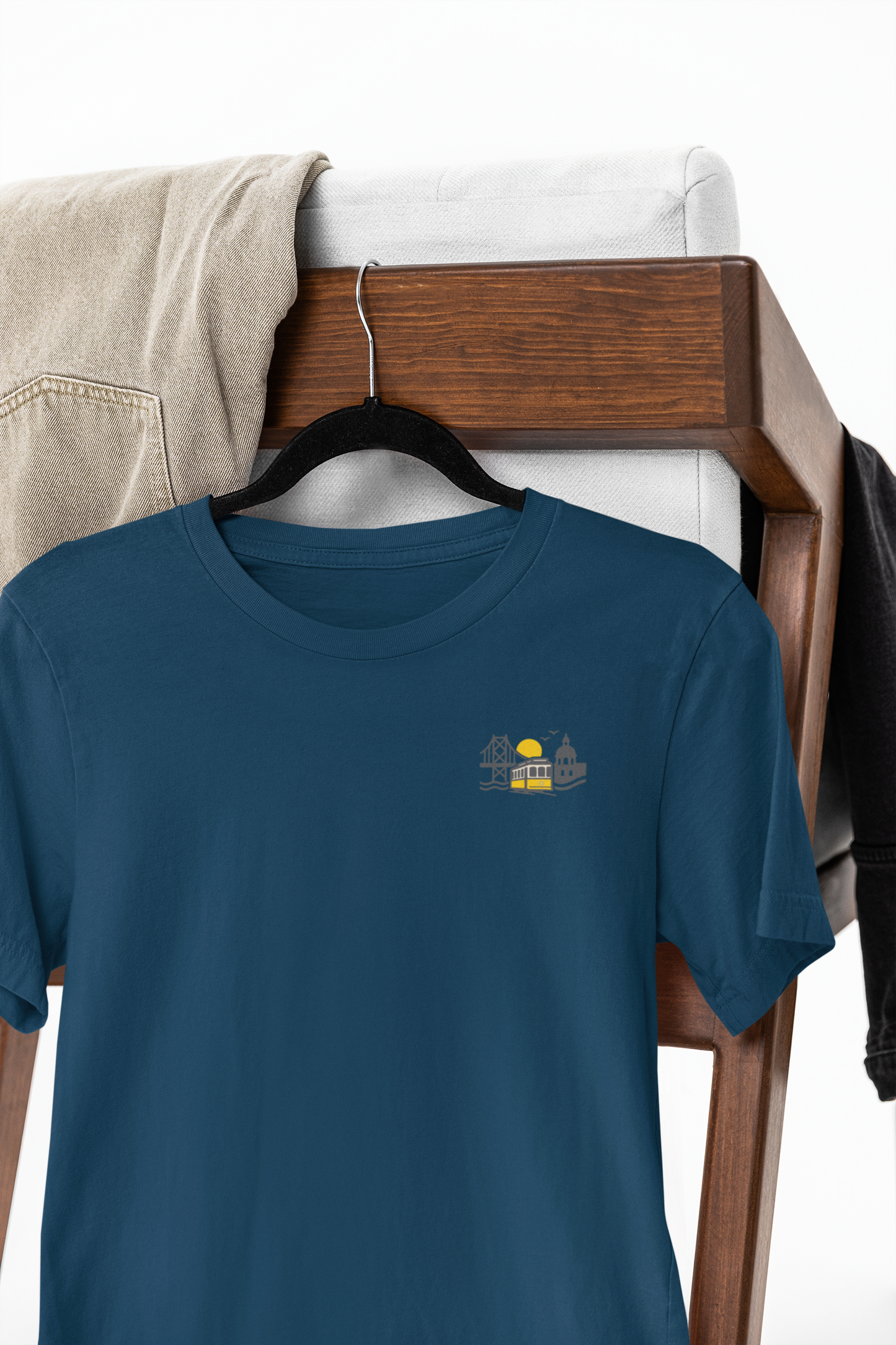 Blue t-shirt with a small graphic on a hanger against a white background